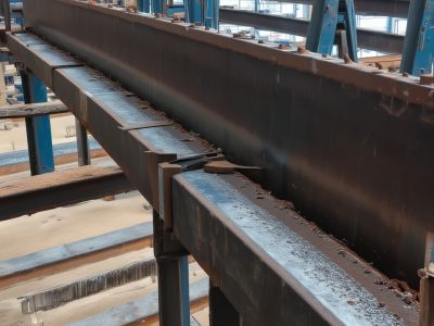 Heavy structural steel beams being welded together in construction environment